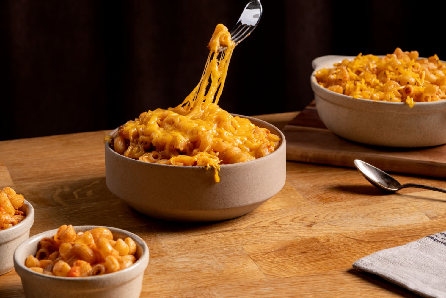 A bowl of creamy macaroni and cheese with a fork resting beside it, ready to be served.  