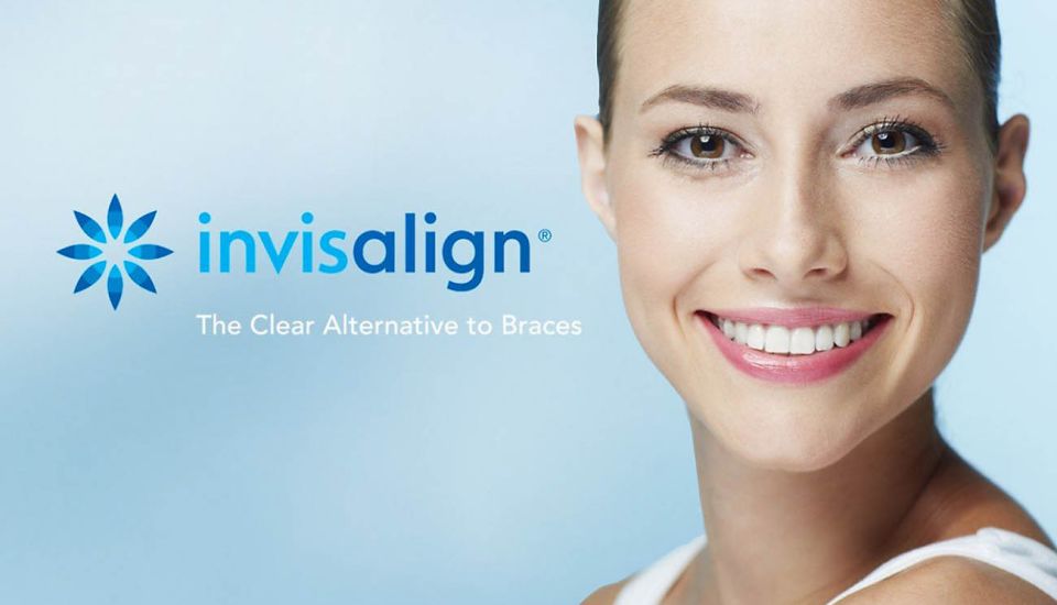 A woman smiles warmly while sitting comfortably on a couch.