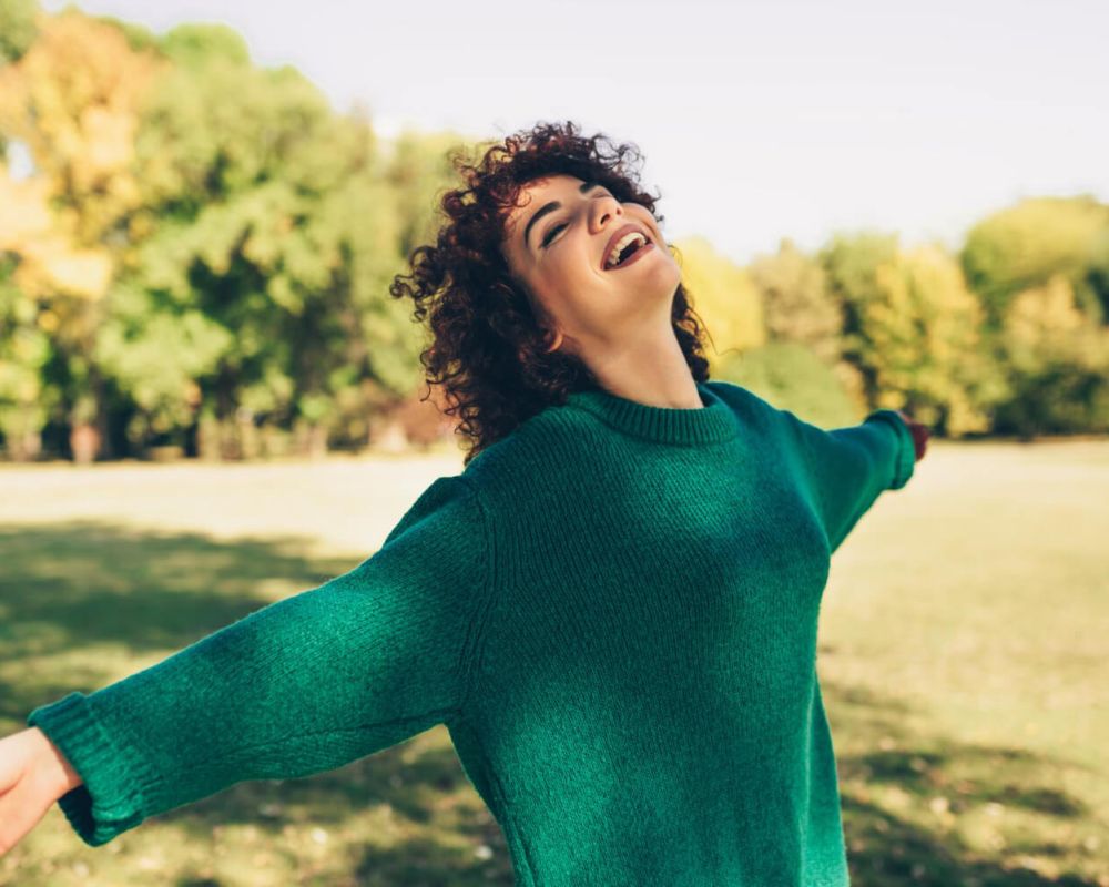 happy young woman smiling posing against nature background
