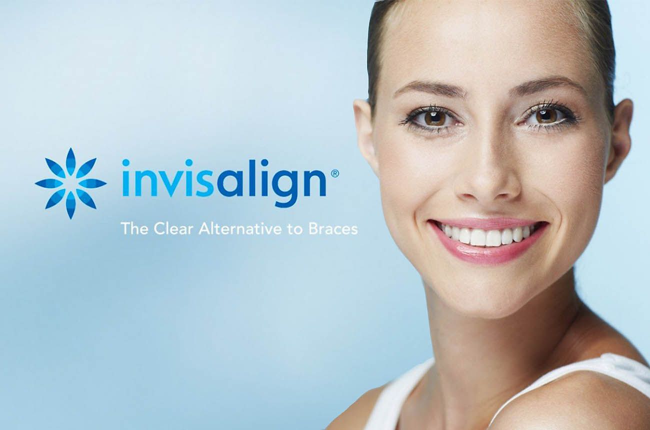 A woman smiles warmly while sitting comfortably on a couch.